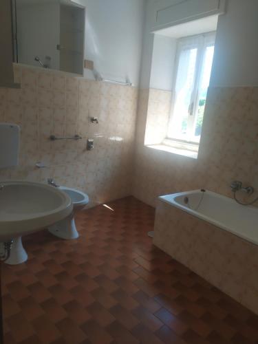 a bathroom with a sink and a tub and a window at Casa del Fra' in Plesio