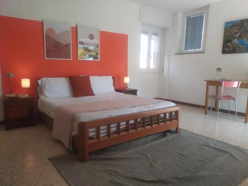 a bedroom with a large bed with a red wall at Casa del Fra' in Plesio