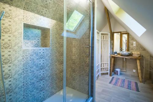 a bathroom with a shower with a glass door at GITES du BOIS des PERRUCHES in Saint-Vincent-des-Bois