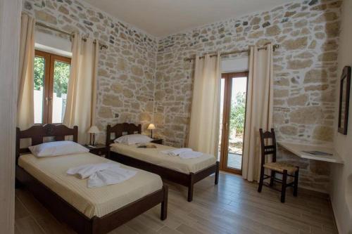 a bedroom with two beds and a stone wall at Iris house Sivas (Ex. Sivas Villa 1) in Sívas