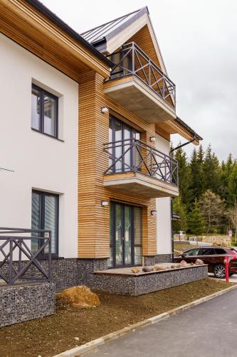 a house with a balcony on top of it at Nela by Mountain ways in Loučná pod Klínovcem