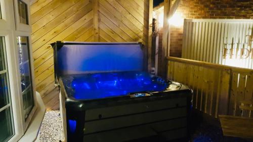 a blue tub in a room with a wooden wall at The Hideaway Thorpe Thewles in Thorpe Thewles