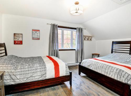 a bedroom with two beds and a window at 14- Chalet à louer à Stoneham in Stoneham