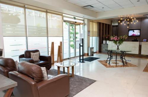 a lobby with a couch and chairs and a table at Hotel Expo Abastos in Guadalajara