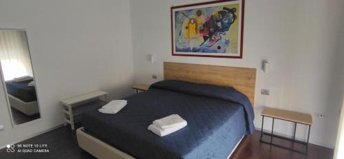 - une petite chambre avec un lit et un miroir dans l'établissement COSENZAGUESTHOUSE, à Cosenza