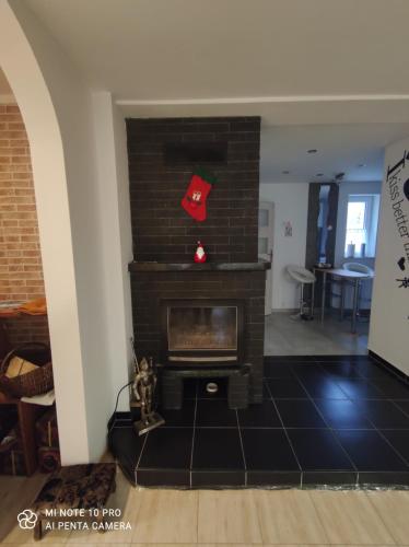 a living room with a brick fireplace with a red hat at WILLA MAŁGORZATA DOM na WYŁĄCZNOŚĆ in Wisła