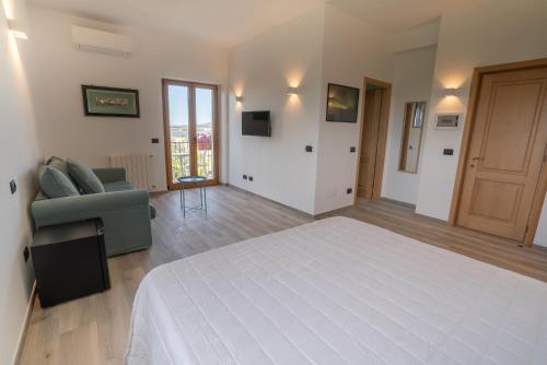 a large bedroom with a white bed and a couch at Antares Rooms and Suites in Olbia