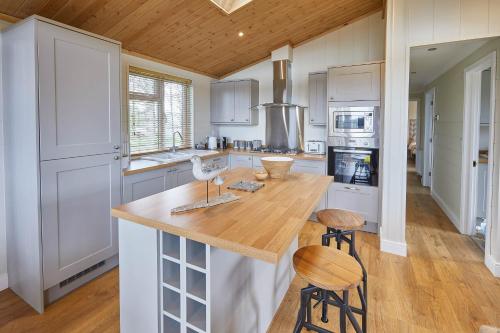 a kitchen with white cabinets and a wooden counter top at Host & Stay - Salt & Seaweed in Runswick