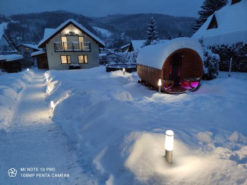 a snow covered yard with a yurt in front of a house at WILLA MAŁGORZATA DOM na WYŁĄCZNOŚĆ in Wisła
