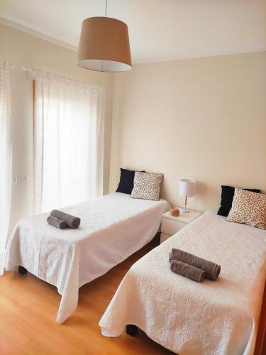 a bedroom with two beds with towels on them at Apartamento Marina Olhão in Olhão