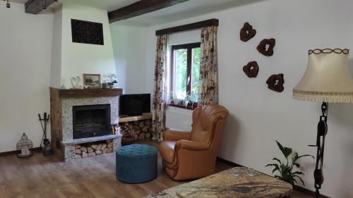 - un salon avec une chaise et une cheminée dans l'établissement DOMEK POD DĘBEM, à Mielnik