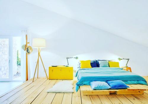 a bedroom with a bed with blue and yellow pillows at Espacio Natural in Valdemorillo