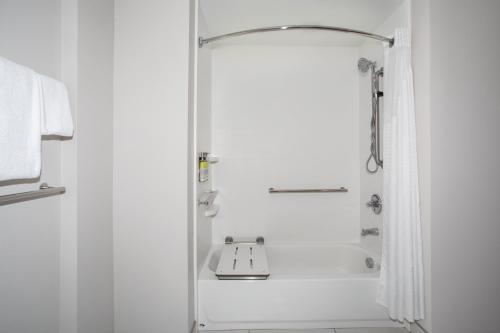 uma casa de banho branca com um chuveiro e um lavatório. em Holiday Inn Express & Suites - Sterling, an IHG Hotel em Sterling