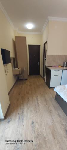 an empty room with a wooden floor and a black door at Квартира у моря Колхида in Makhinjauri