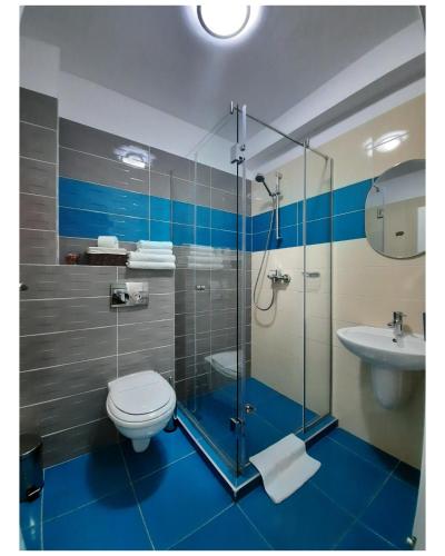 a bathroom with a shower and a toilet and a sink at N.D Global Alba Iulia in Alba Iulia