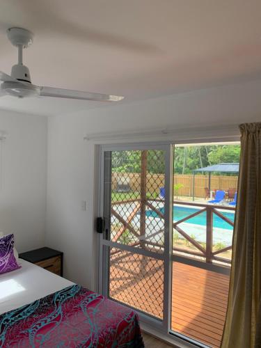 a bedroom with a sliding glass door leading to a pool at Palm Tree Villas in Rarotonga