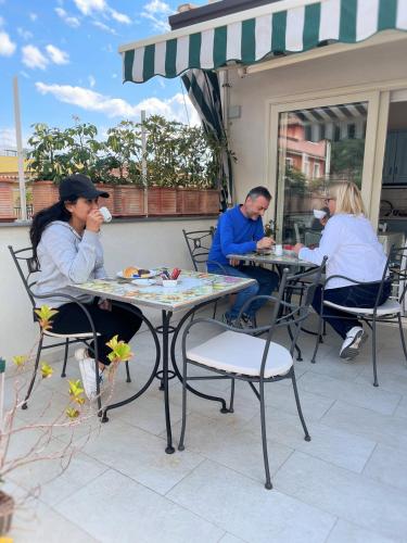 a group of people sitting at tables on a patio at B&B Evelyne in Taormina