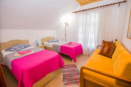 een hotelkamer met twee bedden en een bank bij villa Touzla in Ofrínion