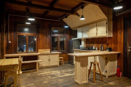 una cocina con armarios de madera y una mesa. en Willa Rawa, en Zakopane