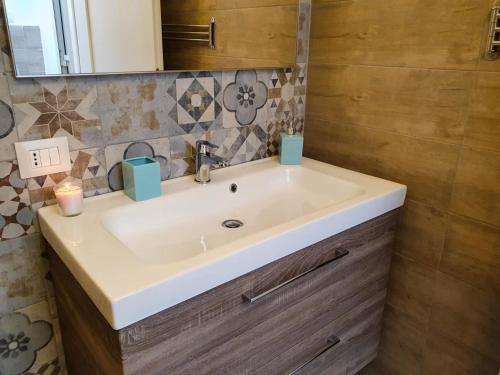 een badkamer met een witte wastafel en een spiegel bij GE Suite in Catania