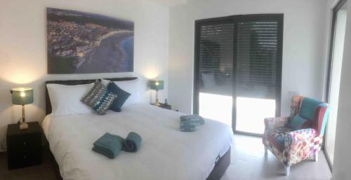 a bedroom with a large white bed and a chair at Villa Casa Tranquilespiral Alcobaça-Nazare in Mendalvo