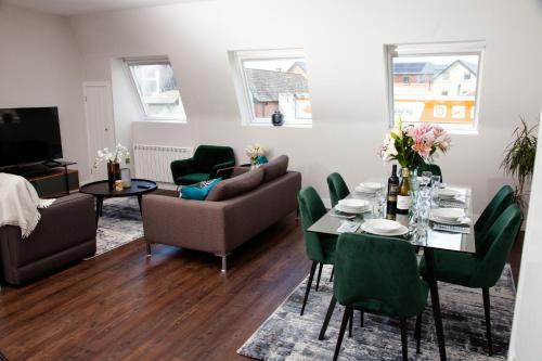 uma sala de estar com uma mesa e cadeiras verdes em High Life Serviced Apartments - Old Town em Swindon