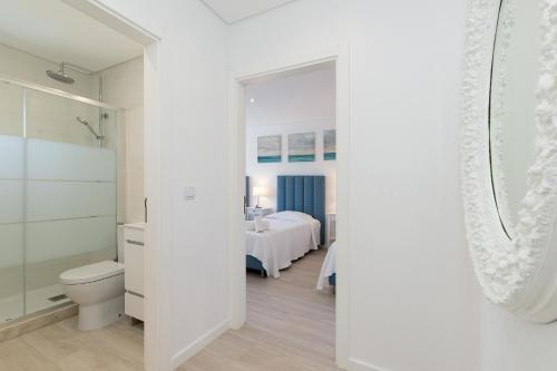 a white bathroom with a toilet and a sink at Villa Tropicana in Albufeira