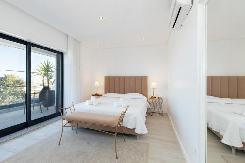 a bedroom with two beds and a large window at Villa Tropicana in Albufeira