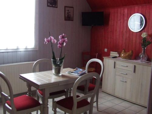 una cocina con una mesa con un jarrón de flores. en Gite les Orchidées, en Honfleur