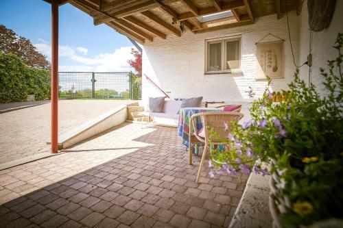 an outdoor patio with a table and chairs and flowers at Vakantiewoning Cha Nostra in Moorveld