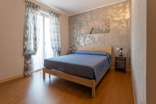 1 dormitorio con cama y ventana grande en Qualità è Amore ROOMS, en Loreto