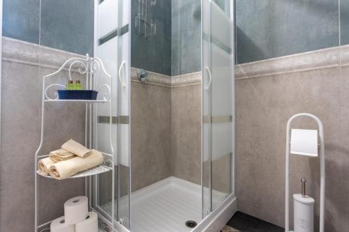 una doccia con porta in vetro in bagno di Qualità è Amore ROOMS a Loreto