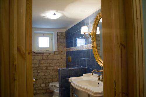 ein Badezimmer mit einem Waschbecken, einem WC und einem Spiegel in der Unterkunft Casarosa B&B de Charme in Cassano delle Murge