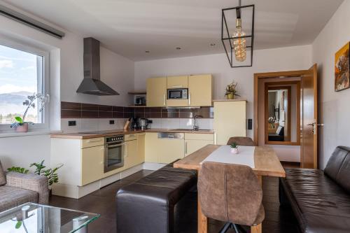 a kitchen and living room with a table and a couch at Elinas Mountain Views in Kaprun