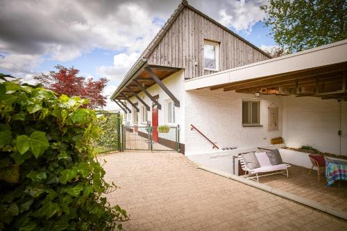 a house with a patio with a couch and chairs at Vakantiewoning Cha Nostra in Moorveld