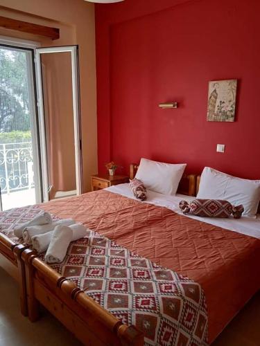 two beds in a bedroom with a red wall at Panorama in Perama