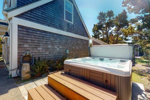 a hot tub on a deck next to a house at Nedonna Beach House in Rockaway Beach