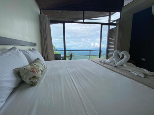 a bedroom with a bed with two swans on it at Casa Linda Vista in Caño Seco