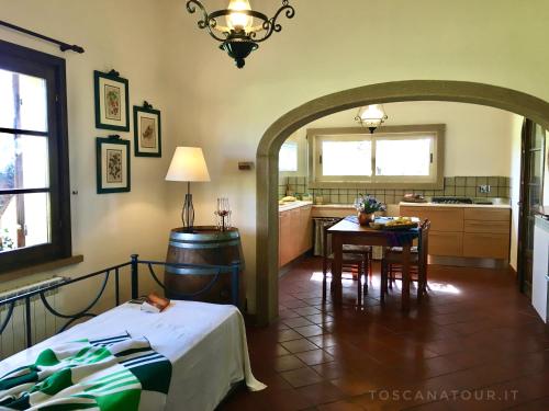 1 dormitorio con cama, mesa y cocina en Cottage I Ciliegi with aircon, fenced garden by ToscanaTour en Cecina