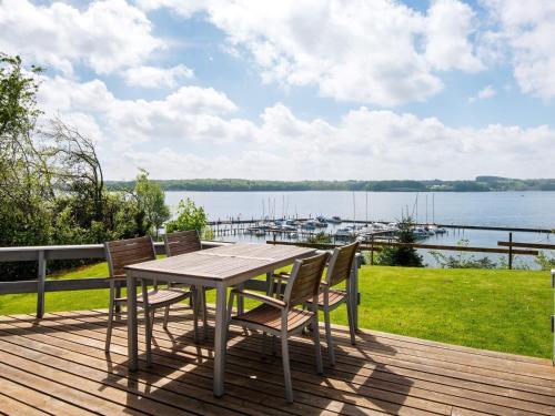 una mesa y sillas en una terraza con vistas al agua en 4 person holiday home in Haderslev en Diernæs