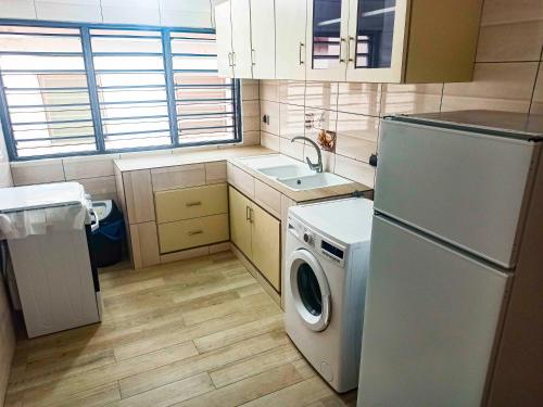 a kitchen with a refrigerator and a washing machine at Appartement F4 Climatisé niveau Etage à Totsi près de la maison ADEBAYOR in Agbalé Pédo