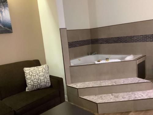 baño con bañera y silla en Best Western Plus Madison, en Madison