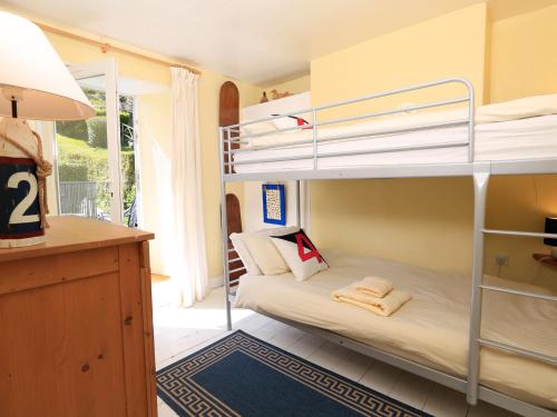 ein Zimmer mit zwei Etagenbetten und Schreibtisch in der Unterkunft Aune Cottage in Salcombe