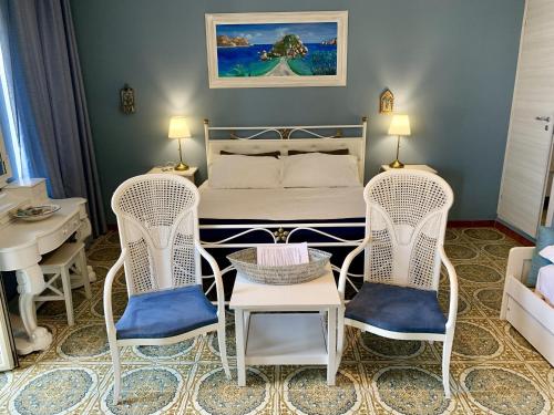 a bedroom with a bed and two chairs and a table at B&B A Due Passi Dal Mare in Taormina
