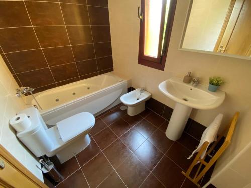 a bathroom with a toilet and a sink and a tub at Apartamento LLAR DEL CARES in Arenas de Cabrales