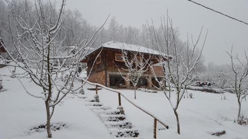 a snow covered log cabin with snow on the roof at Ethno Village Bogut in Bogutovac