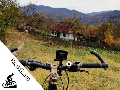 a picture of the handlebars of a bike in front of a house at Ethno Village Bogut in Bogutovac
