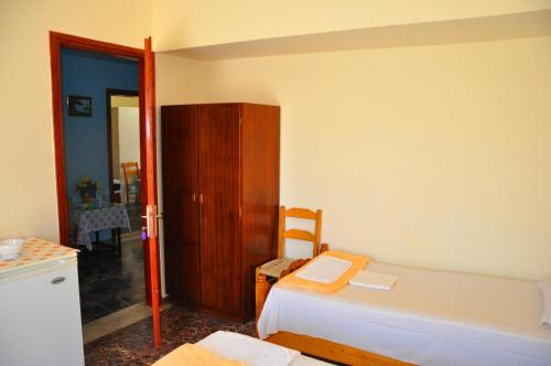 1 dormitorio con 1 cama y armario de madera en Vai Rent Rooms en Palekastron