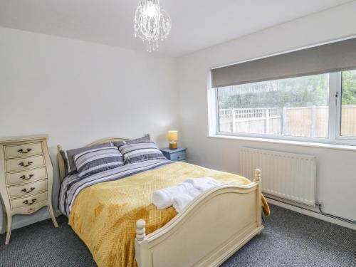 a white bedroom with a bed and a window at 22 Gwel Yr Wyddfa in Menai Bridge