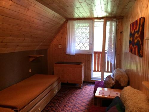 een kleine kamer met een bed en een raam bij Rekreačná Chata in Jakubovany